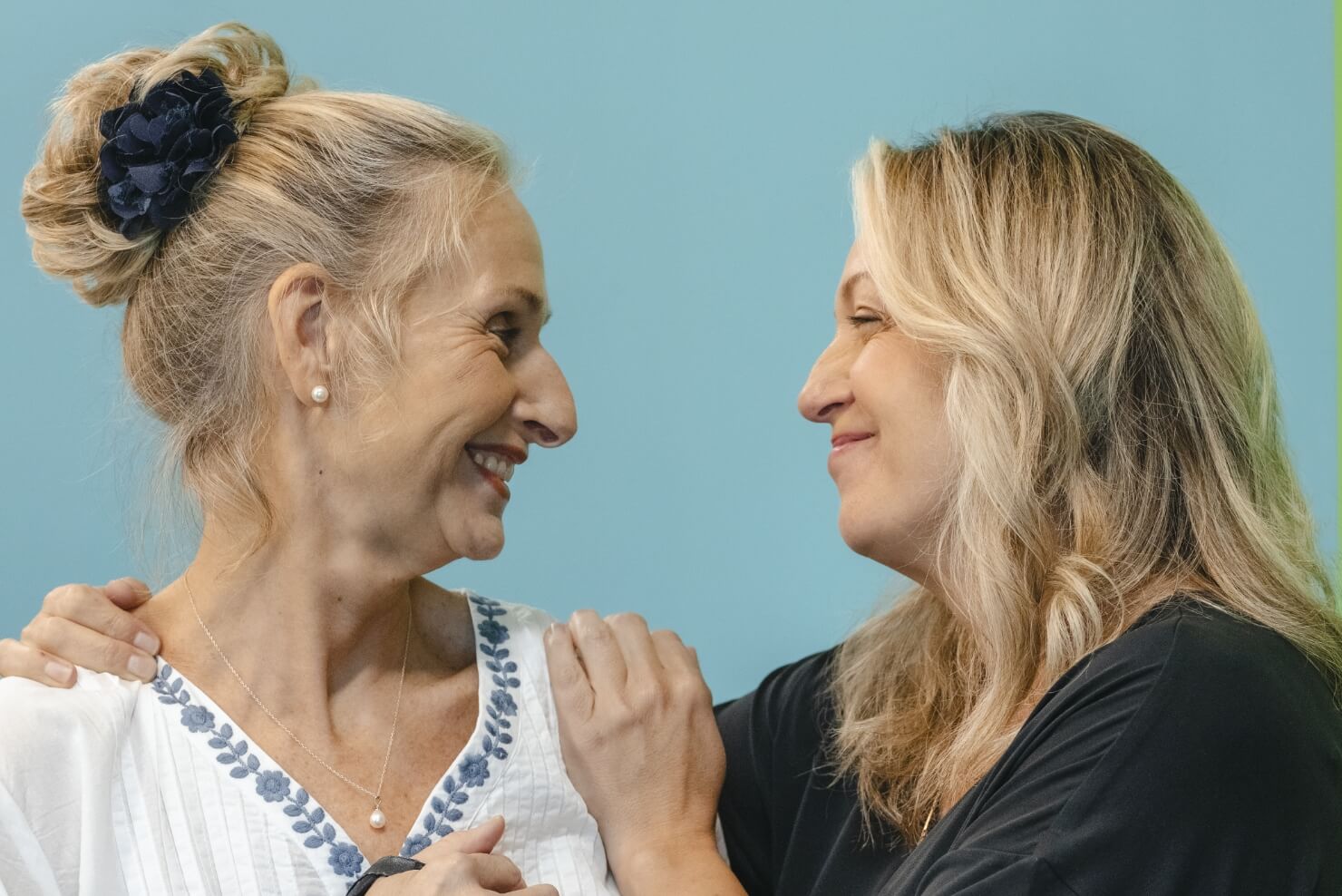 A woman touching another woman's shoulder as a sign of support